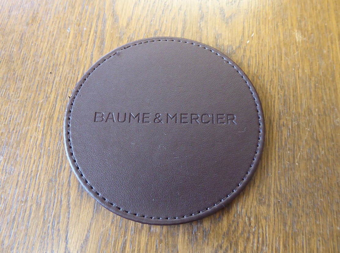 A Set Of Six Baume & Mercier Leather Coasters